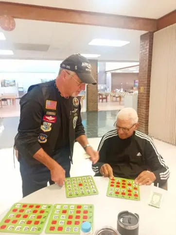 A man and an older gentleman playing a game of chess.