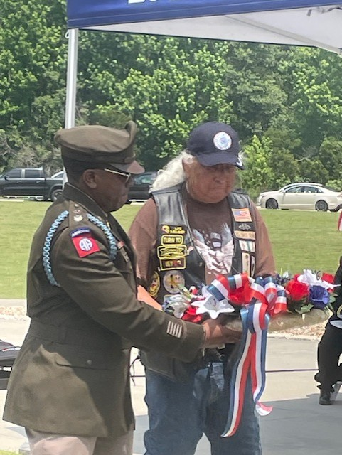 A man and woman holding flags on the side of a road.