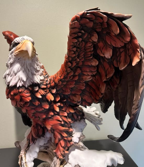 A large bird statue with feathers on it's wings.